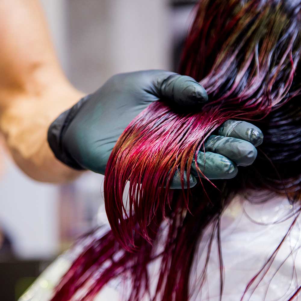 Professioneller Friseur, der Haare färbt. Mehrfarbig mit dehnbarer Färbung