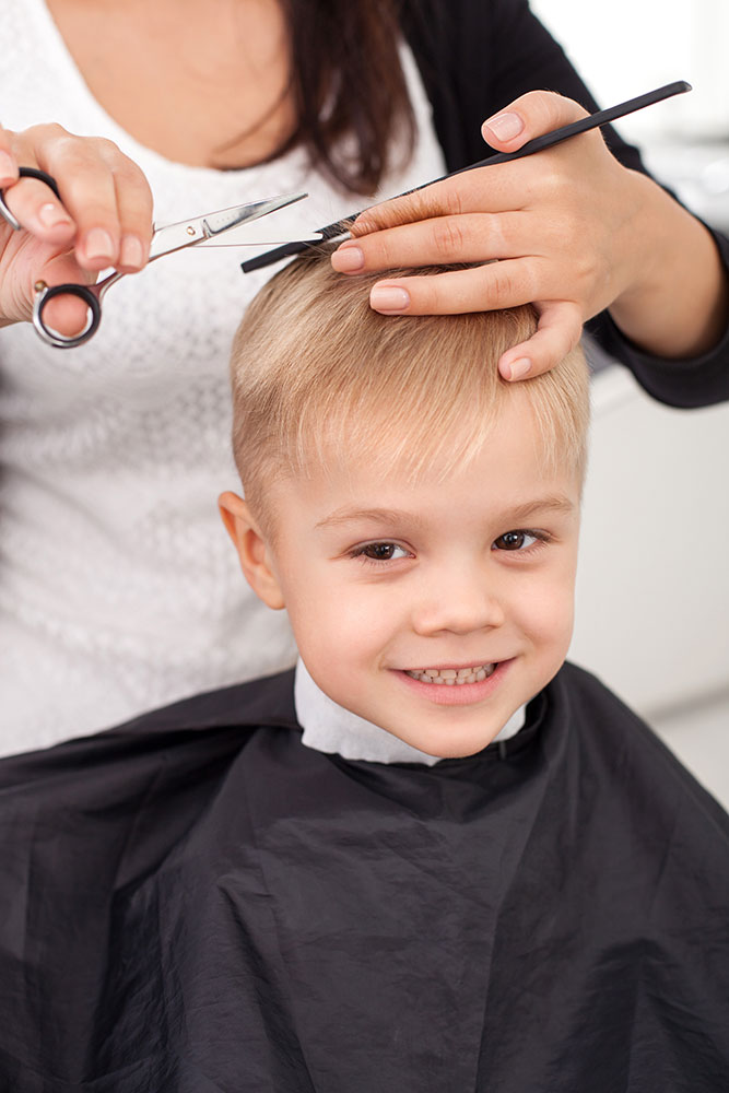 Erfahrene junge Friseurin macht einen Haarschnitt