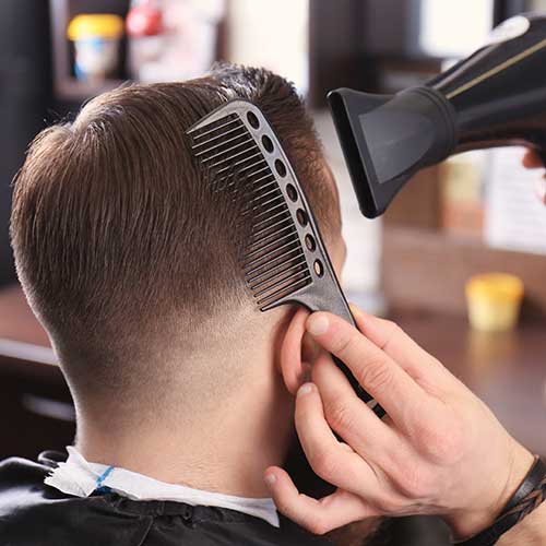 Friseur macht moderne männliche Frisur